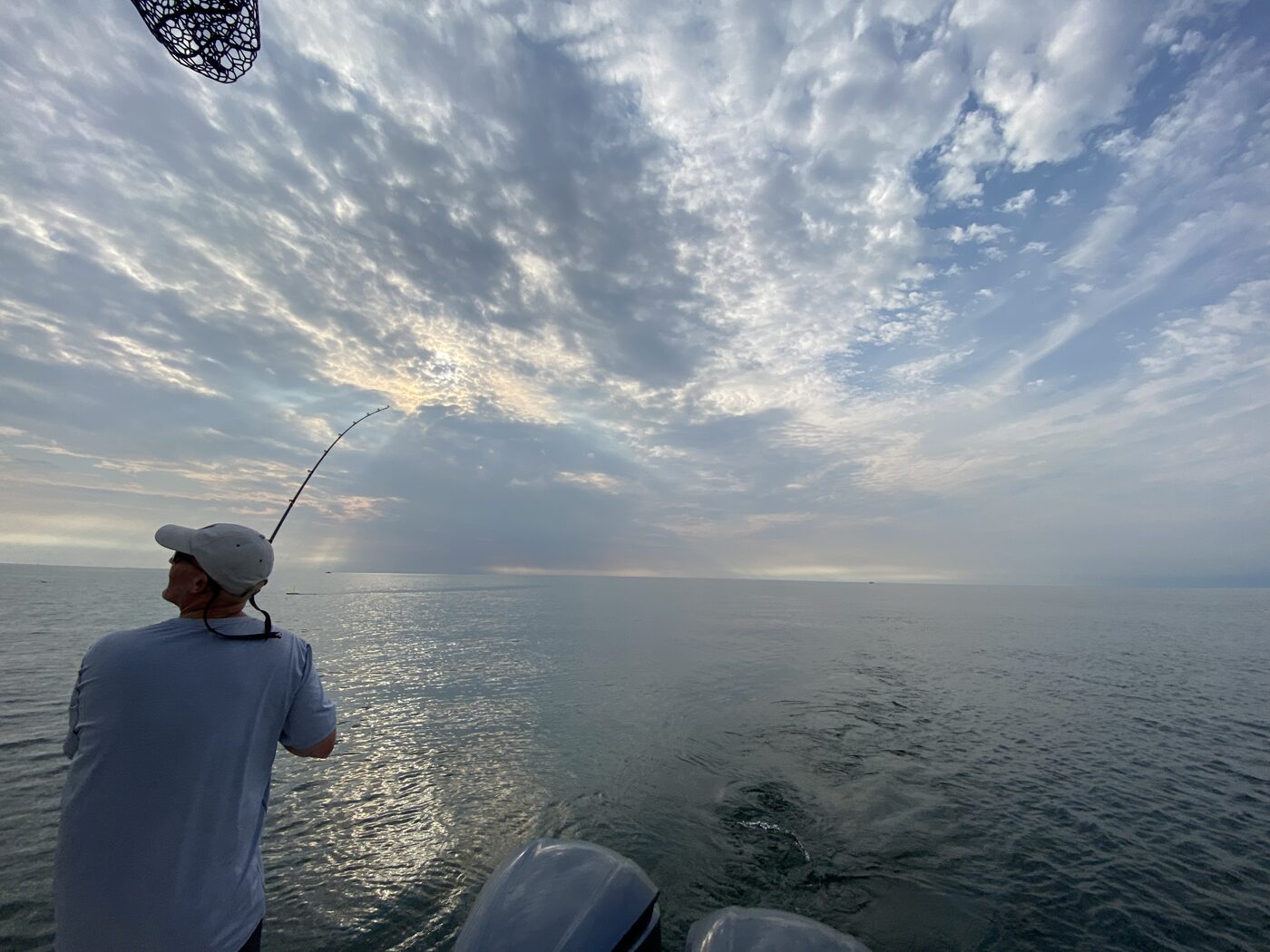 An angler playing a fish off the back of a charter boat