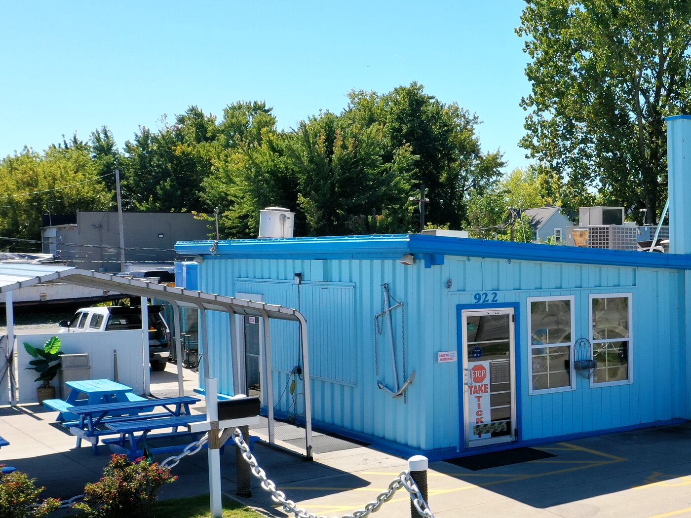 The blue storefront at 922 Colorado Avenue, picnic tables under the awning